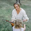 Kasia outside teaching a young girl how to play the violin